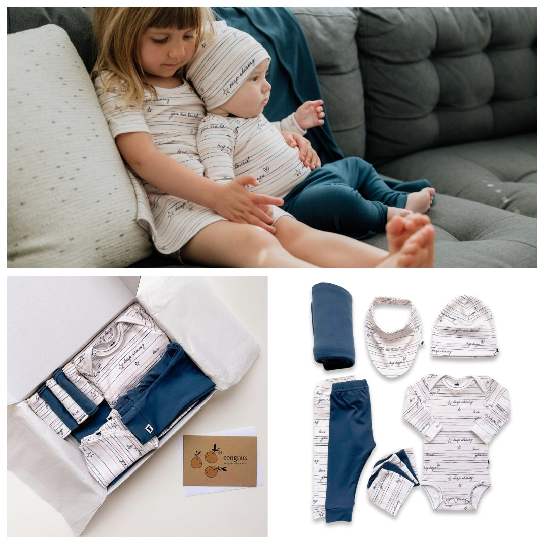 Two children sitting on a couch with baby clothing and accessories displayed below.